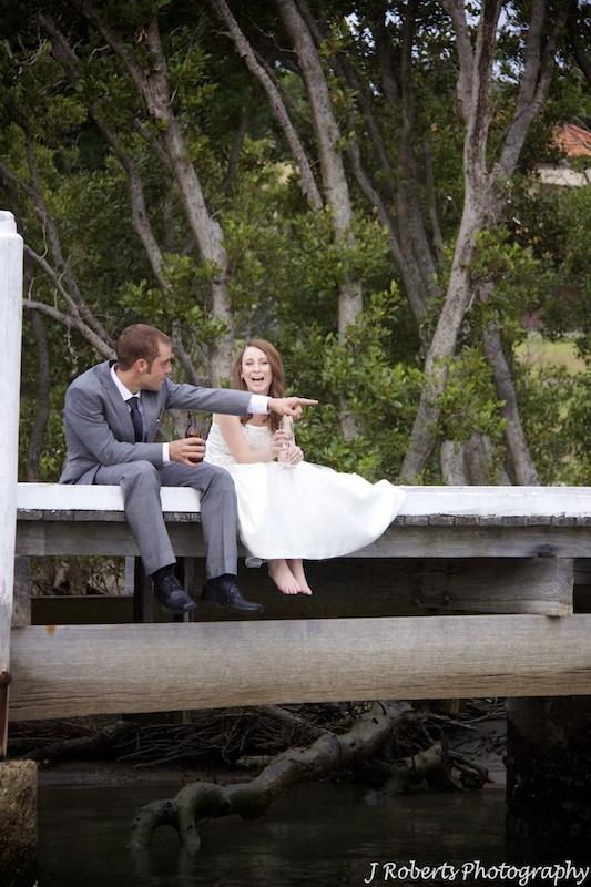 Bride and groom sitting on a jetty - wedding photography sydney